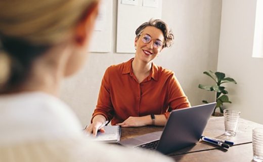 Happy hiring manager smiling while interviewing a job candidate in her office. Cheerful businesswoman having a meeting with a shortlisted job applicant in a creative workplace.