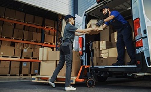 Outside,Of,Logistics,Distributions,Warehouse:,Diverse,Team,Of,Workers,Use Outside of Logistics Distributions Warehouse: Diverse Team of Workers use Hand Truck Loading Delivery Van with Cardboard Boxes, Online Orders, E-Commerce Purchases.